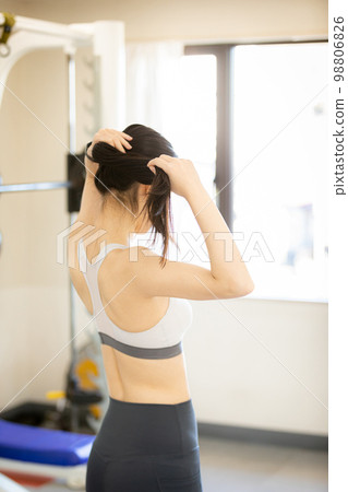 Young woman tying her hair up before exercising 98806826