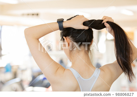 Young woman tying her hair up before exercising 98806827