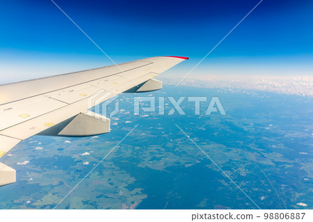 View from the airplane window at a beautiful cloudy sky and the airplane wing 98806887