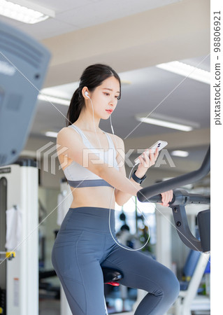 一邊聽音樂一邊享受健身房的年輕女性 一邊聽音樂一邊享受健身房的年輕女性 98806921