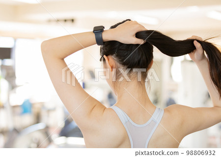 Young woman tying her hair up before exercising 98806932