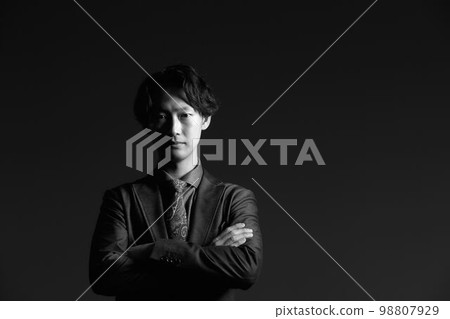 年輕商人一邊折疊雙臂一邊看單色圖像 98807929