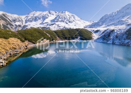 Drone aerial photography Tateyama Murodo's Mikuriga pond in early winter Tateyama mountain range and Mt. Jodo Drone aerial photography Tateyama Murodo's Mikuriga pond in early winter Tateyama mountain range and Mt. Jodo 98808189