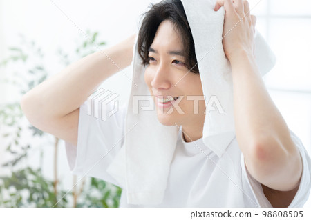 Handsome man wiping his hair with a towel Handsome man wiping his hair with a towel 98808505