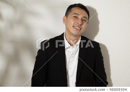 A man in a black suit and no tie A man in a black suit and no tie 98809304