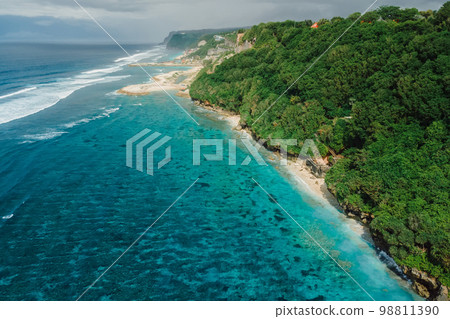 Aerial view of scenic coastline with turquoise ocean and beaches under cliffs in Bali. Aerial view of scenic coastline with turquoise ocean and beaches under cliffs in Bali. 98811390