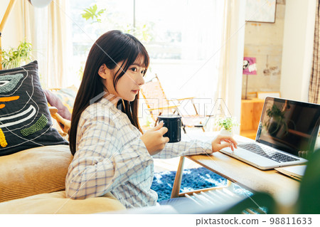 Young woman working remotely Young woman working remotely 98811633