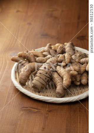 Bamboo shoots and autumn turmeric rhizomes on wooden table Bamboo shoots and autumn turmeric rhizomes on wooden table 98812530
