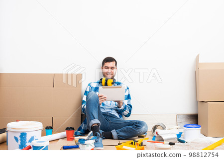 Smiling man surfing internet on tablet computer 98812754