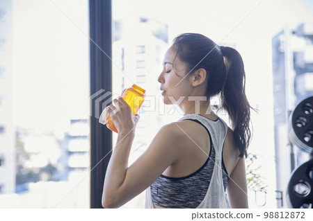 在健身房補水的年輕女子 98812872