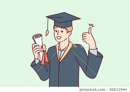 Graduate guy in academic gown and hat holds bundle with diploma and shows thumbs up Graduate guy in academic gown and hat holds bundle with diploma and shows thumbs up 98812944