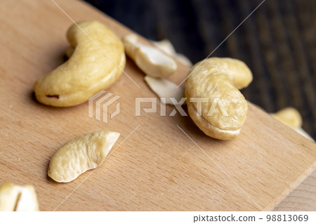 a few raw cashew nuts on the board 98813069