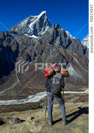 Hiker woman posing with mountains at background 98814847