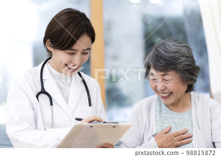 Female doctor examining a senior woman Home visit Home medical treatment 98815872