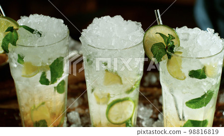 Fresh mojito cocktails on the bar, dark toned background Fresh mojito cocktails on the bar, dark toned background 98816819