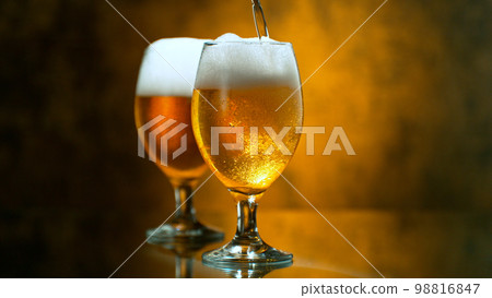 Freshly brewed beer in a pint on orange gradient background, close-up 98816847