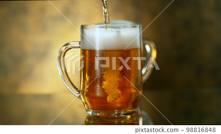 Freshly brewed beer in a pint on orange gradient background, close-up 98816848
