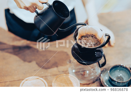 A young female clerk dripping coffee faceless 98816878