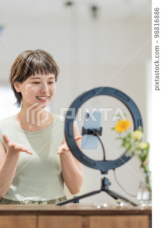 Young woman talking to followers on video distribution 98816886