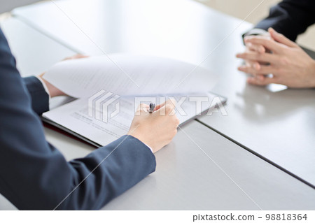 Hands of a woman conducting a business interview Hands of a woman conducting a business interview 98818364