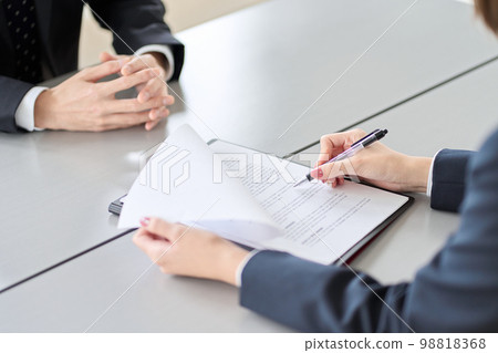 Hands of a woman conducting a business interview Hands of a woman conducting a business interview 98818368
