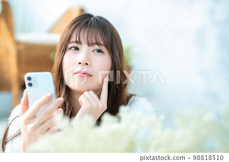 年輕女性在使用智能手機時思考 98818510