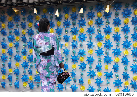 The back view of a young woman in a yukata, the cool summer scenery of downtown, and the breeze is Instagrammable The back view of a young woman in a yukata, the cool summer scenery of downtown, and the breeze is Instagrammable 98819699