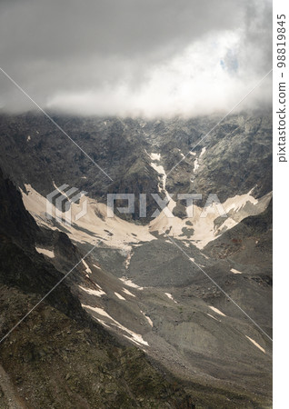 horizontally, close-up of a rocky snowy ridge of mountains in the fog horizontally, close-up of a rocky snowy ridge of mountains in the fog 98819845