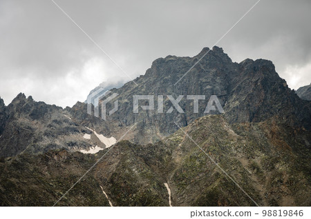 Rocky mountain range close-up, snow lies somewhere, cloudy weather Rocky mountain range close-up, snow lies somewhere, cloudy weather 98819846