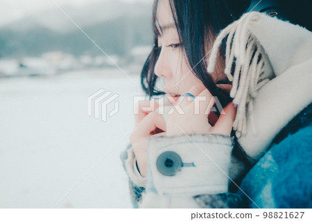 一位年輕女子在雪地裡聽音樂的照片 98821627