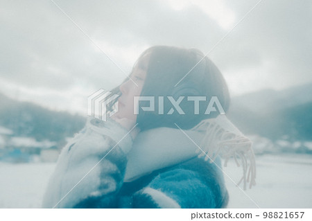 一位年輕女子在雪地裡聽音樂的照片 一位年輕女子在雪地裡聽音樂的照片 98821657