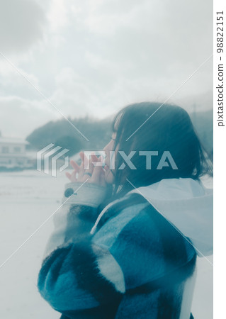 Photo of a young woman holding an umbrella in the snow 98822151