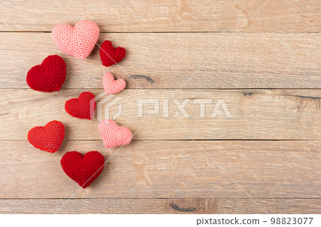 Multicolored knitted hearts on a wooden background. Happy Valentine's Day, Mother's Day and birthday greeting card. Flat lay Multicolored knitted hearts on a wooden background. Happy Valentine's Day, Mother's Day and birthday greeting card. Flat lay 98823077