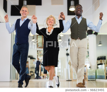 Elderly woman with two men dancing together Elderly woman with two men dancing together 98823491