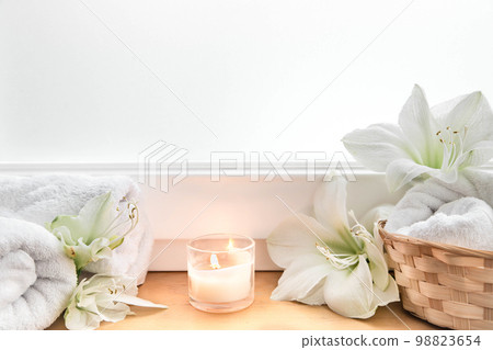 Spa composition with lily flowers and towels in a basket. Spa composition with lily flowers and towels in a basket. 98823654