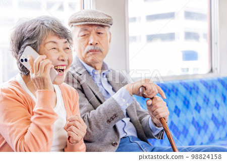 在火車上用智能手機交談的高級女性 98824158