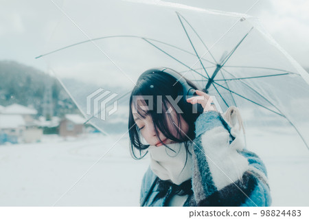 Photo of a young woman listening to music in the snow Photo of a young woman listening to music in the snow 98824483