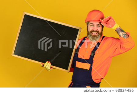 Repairman hold blackboard copy space. Handsome repairman. Price list. Repair company services. Architect demonstrating project. Professional repairman. Visual outline. Bearded man repairman builder 98824486