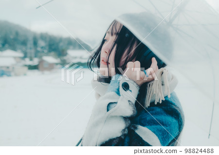 一位年輕女子在雪地裡聽音樂的照片 一位年輕女子在雪地裡聽音樂的照片 98824488