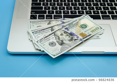 Close up, dollar bills on laptop, money making concept. Close up, dollar bills on laptop, money making concept. 98824836