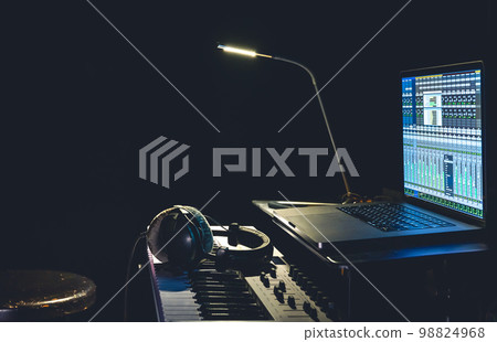 MIDI keyboard, headphones and a laptop with a program for creating music. MIDI keyboard, headphones and a laptop with a program for creating music. 98824968