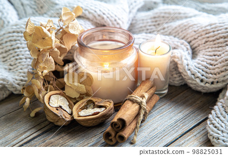 Still life with a candle and a knitted element. 98825031