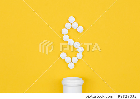 Tablets laid out in the shape of a dollar, conceptual minimalism. 98825032