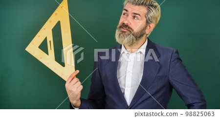 study mathematics lesson. use in architecting and geometry. bearded man engineer in suit. angle measure in physics. math teacher use triangle ruler. back to school. precision measurement study mathematics lesson. use in architecting and geometry. bearded man engineer in suit. angle measure in physics. math teacher use triangle ruler. back to school. precision measurement 98825063