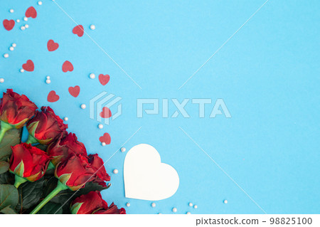 Bouquet of red roses and decorative hearts on a blue background, flat lay. Bouquet of red roses and decorative hearts on a blue background, flat lay. 98825100