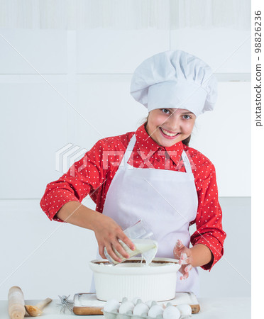 working. Healthy eating and lifestyle concept. girl making dough from flour and eggs. dieting and health. culinary school. traditional cuisine. kid having fun with food at kitchen. Child and baking 98826236