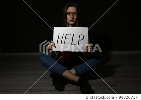 Abused young woman with sign HELP on black background. Domestic violence concept 98826717