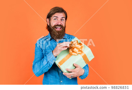 mature man with beard and trendy hairstyle hold gift box, discount 98826831