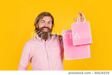 mature man with beard and trendy hairstyle hold gift package, shopaholic mature man with beard and trendy hairstyle hold gift package, shopaholic 98826839