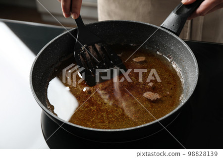 Woman holding frying pan with used cooking oil, closeup 98828139